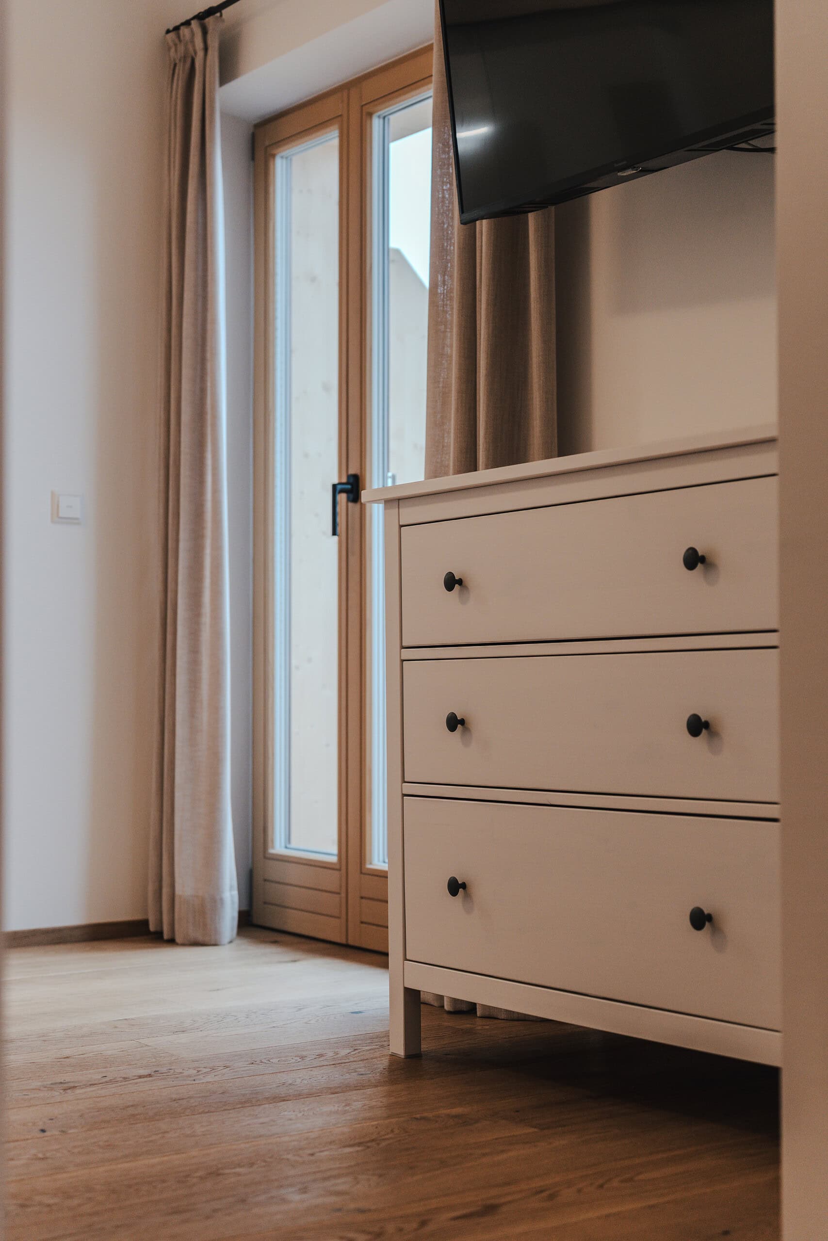 Gemütliches Zimmer mit Blick auf den Balkon und Natur.