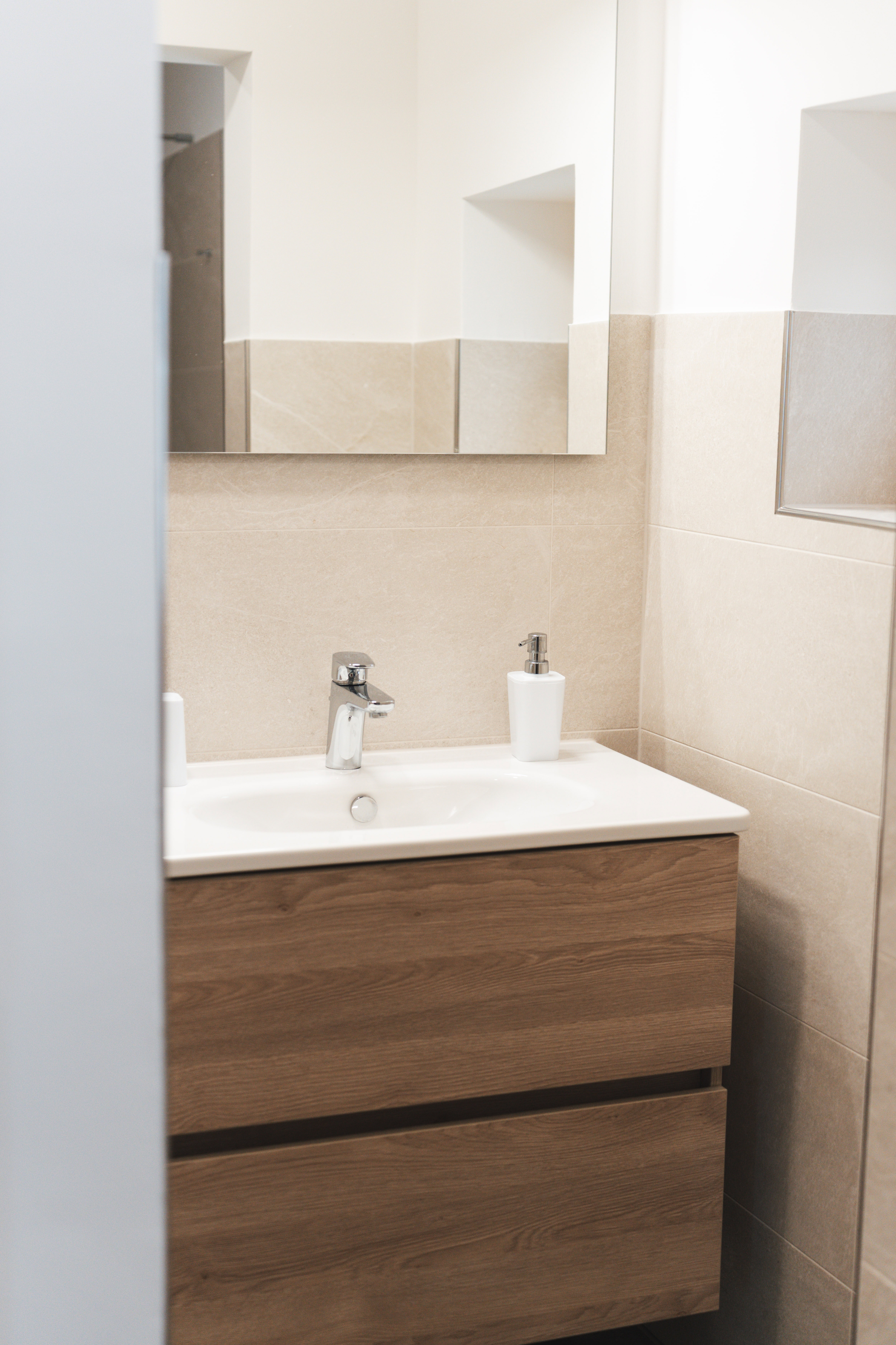 Helles Badezimmer mit Waschbecken und Spiegel im Gästehaus Reit im Winkl.