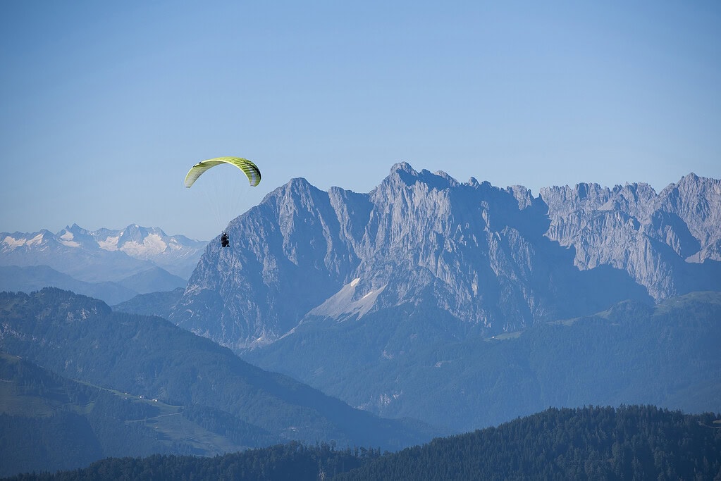 Gleitschirmflieger über den Bergen in Reit im Winkl, mit Blick auf die Alpen.