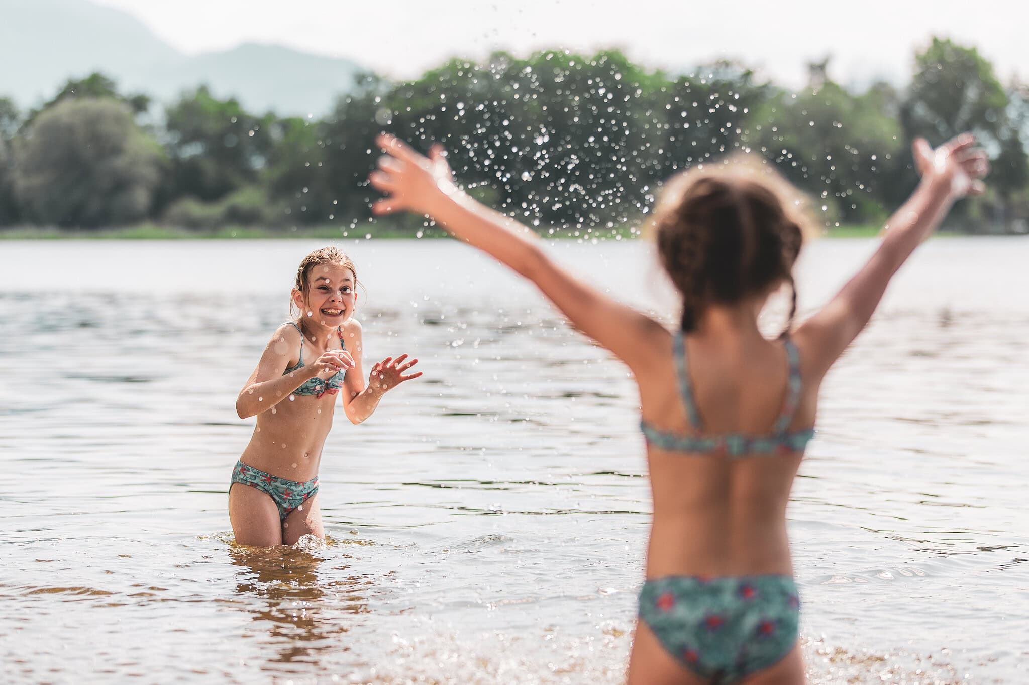 Kinder spielen fröhlich im Wasser am See in Reit im Winkl.