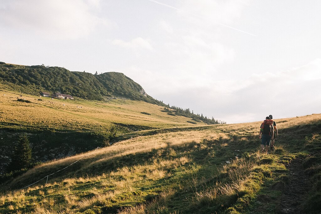 Bergwanderer auf dem Weg im Grünen bei Reit im Winkl, Bayern, mit Blick auf die umliegenden Berge.