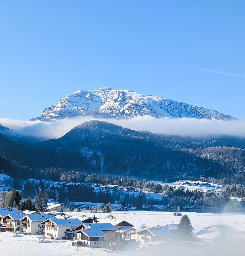 Gästehaus am Kurparkweg in Reit im Winkl mit Blick auf verschneite Berge und Winterlandschaft.
