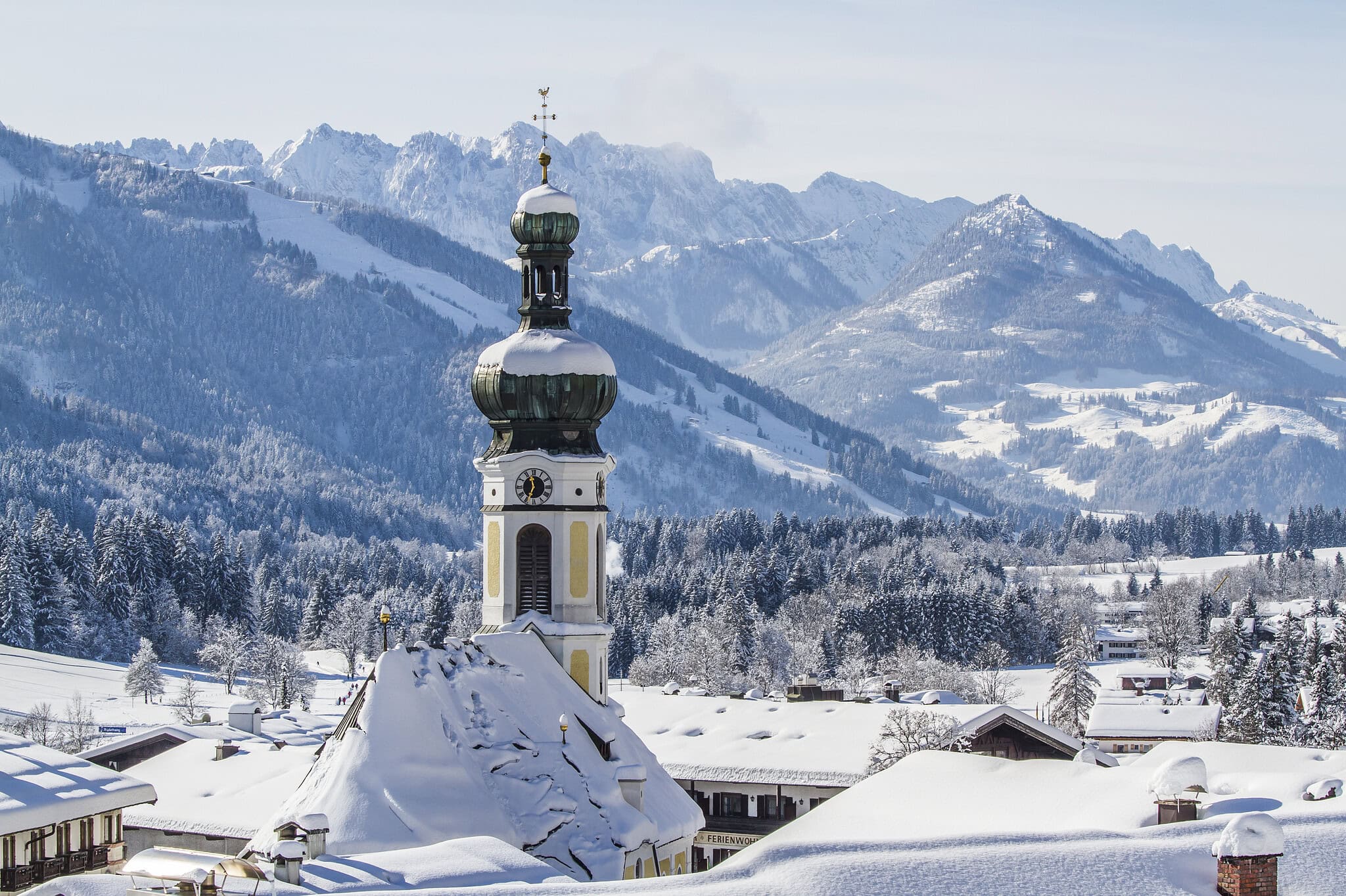 Gästehaus am Kurparkweg in Reit im Winkl mit Blick auf verschneite Berge und traditionelle bayerisch.