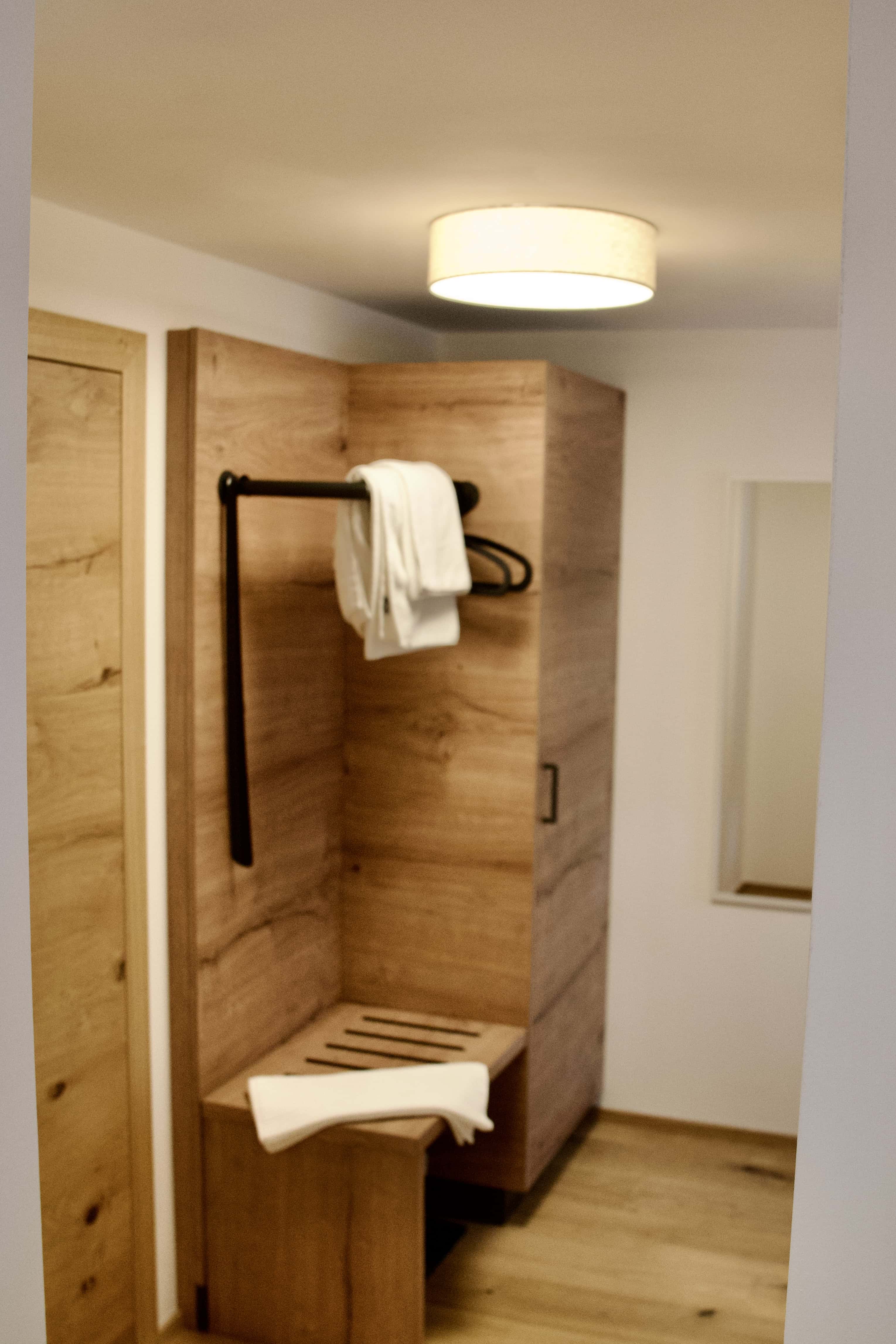 Gemütliches Gästezimmer mit Holzdesign und Sitzgelegenheit.