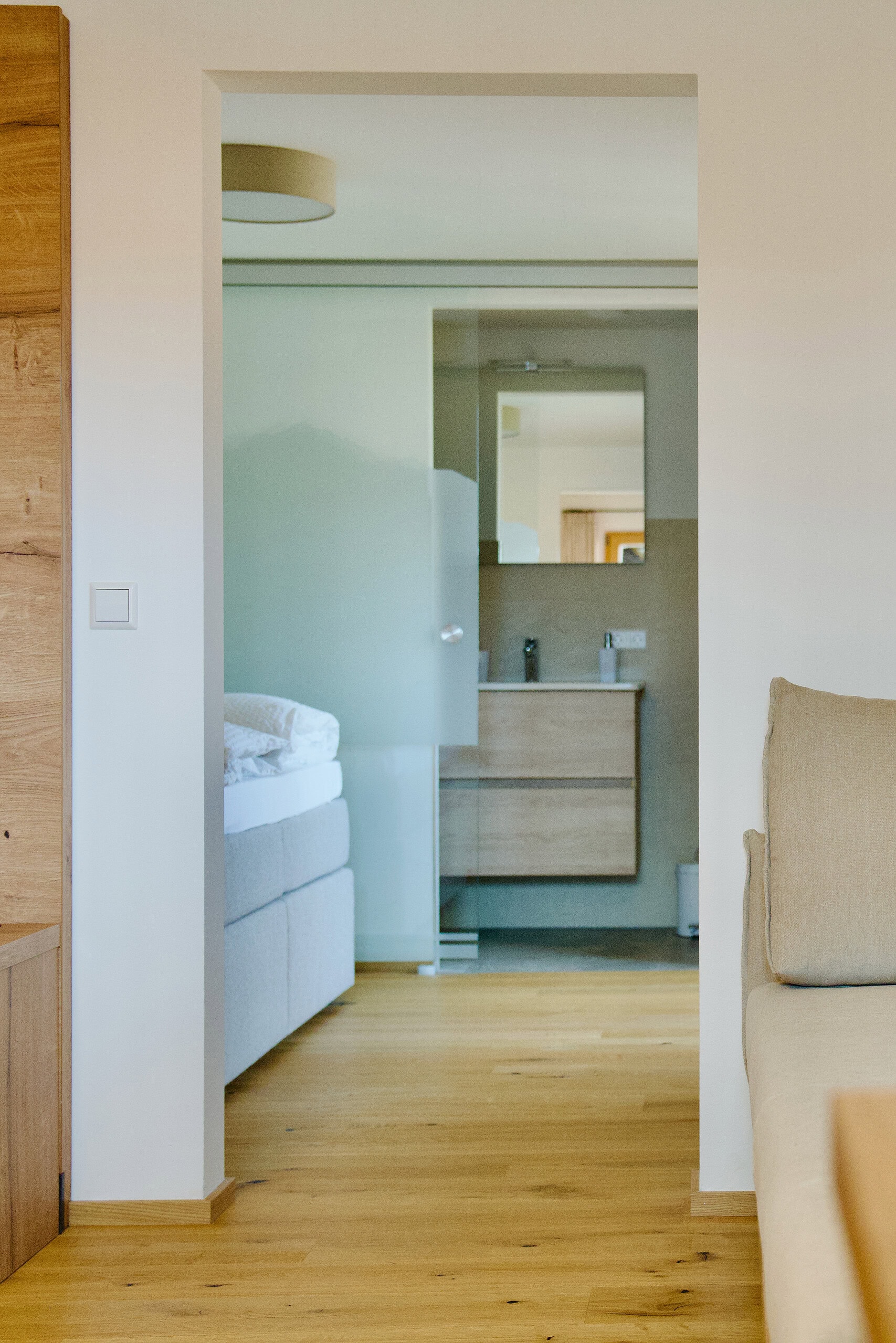 Modernes Gästezimmer mit Blick ins Badezimmer im Gästehaus Reit im Winkl.